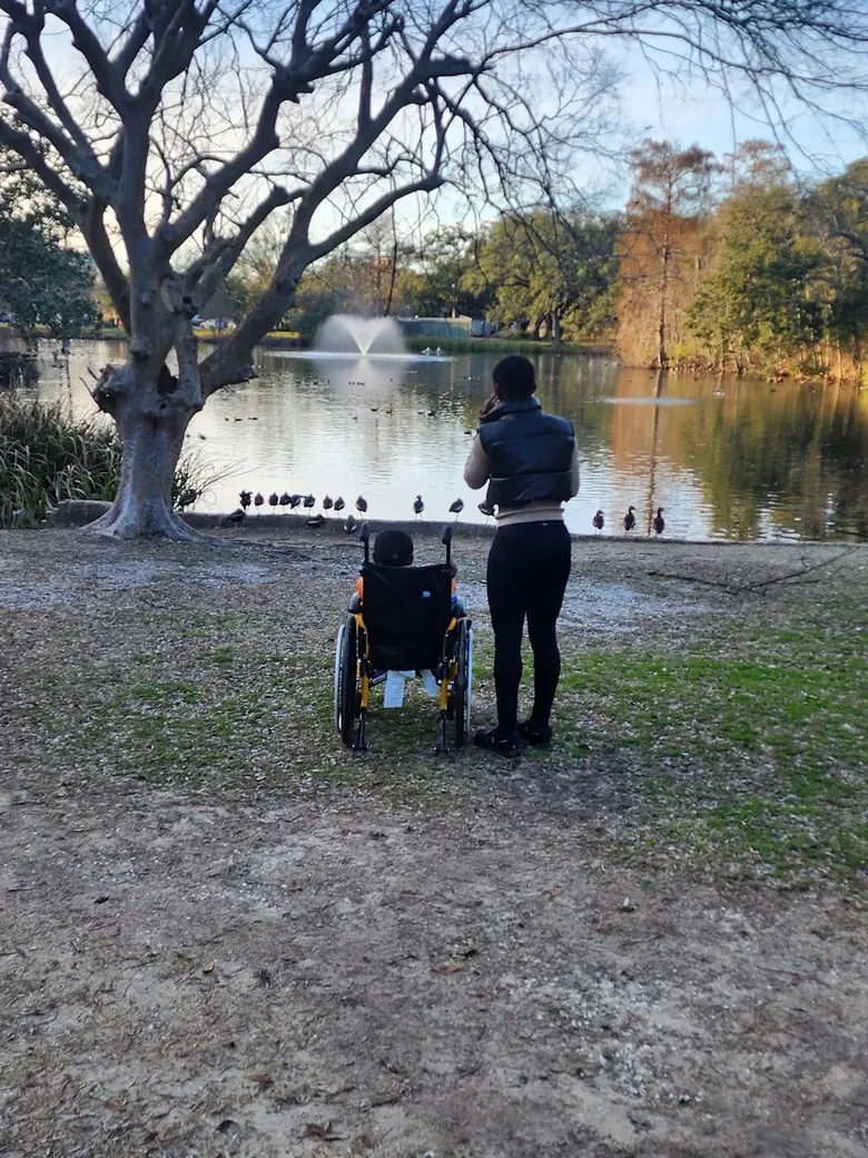 A parent and child side by side at the lake, unhurried.