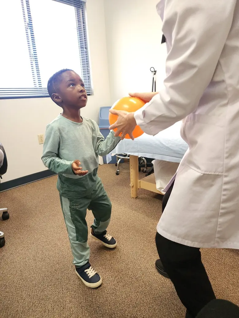 Justus reaching upward during a therapy session.